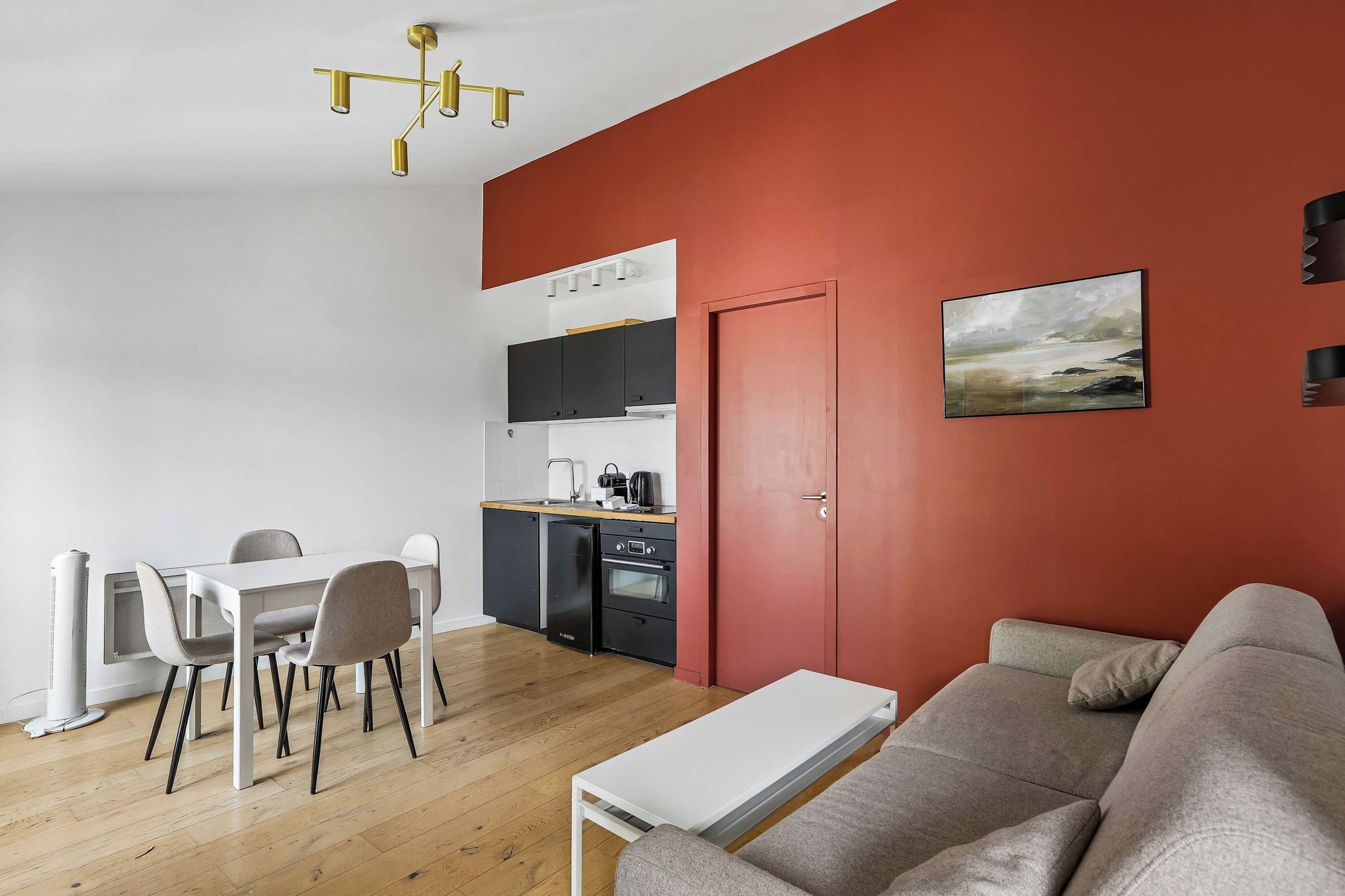 Un espace de vie compact comprenant un coin repas, une kitchenette et un canapé.