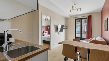 Eine moderne Küche mit Spüle aus Edelstahl und einem Essbereich mit Holztisch und Stühlen.