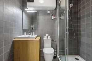 Une salle de bain moderne équipée d’une douche, de toilettes et d’un lavabo.