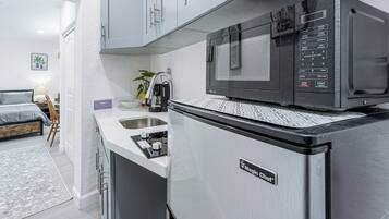 A compact kitchen with a microwave, a refrigerator, and a sink.