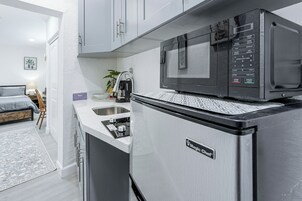 A compact kitchen with a microwave, a refrigerator, and a sink.