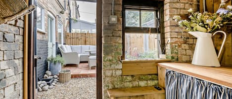 A rustic interior with a wooden bench, a small table, and a window with a view of the outside.