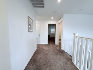 A hallway with carpeted flooring, white walls, and a door leading to another room. - Luxury 5B 3B Near Casino Ac Prking Greatneighbors (Elk Grove)