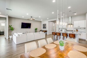 A modern kitchen with white cabinets, a central island, and pendant lighting. - Gather - Relax - Stay Awhile - Near Ballparks Mts (Goodyear)