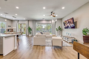A spacious living area with a kitchen, dining area, and a large window offering a view of the outdoors. - Gather - Relax - Stay Awhile - Near Ballparks Mts (Goodyear)