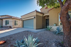 A residential property with a garage, a driveway, and landscaping. - Desert Oasis: Tucson Home w/ Private Swim Spa (Tucson)