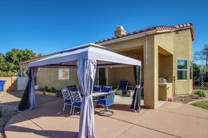 A covered patio area with a table and chairs, a small building with a window, and a clear blue sky. - Desert Oasis: Tucson Home w/ Private Swim Spa (Tucson)