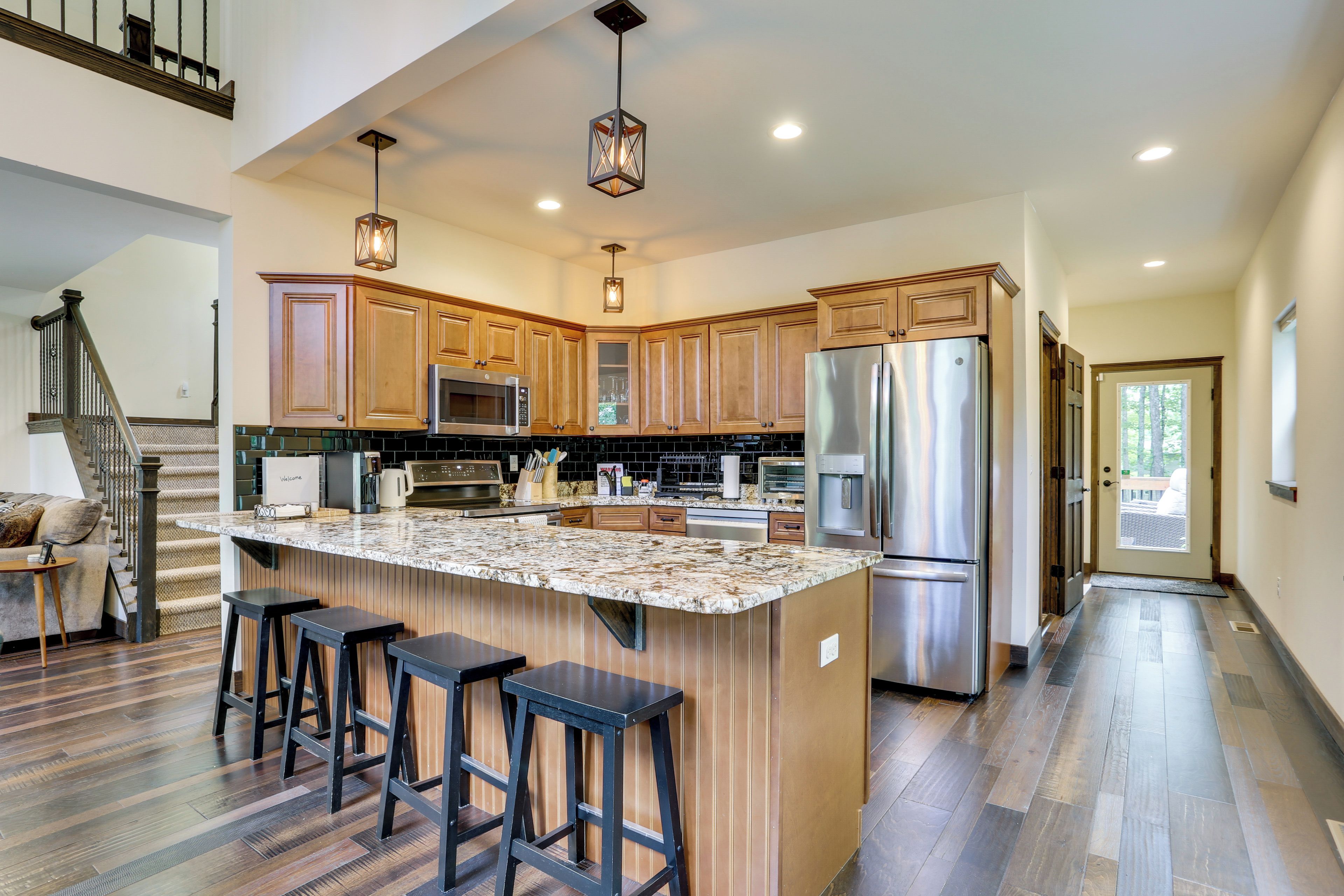 A modern kitchen with a central island, stainless steel appliances, and wooden cabinetry.