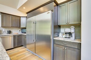 A modern kitchen with stainless steel appliances, a coffee maker, and a built-in oven.