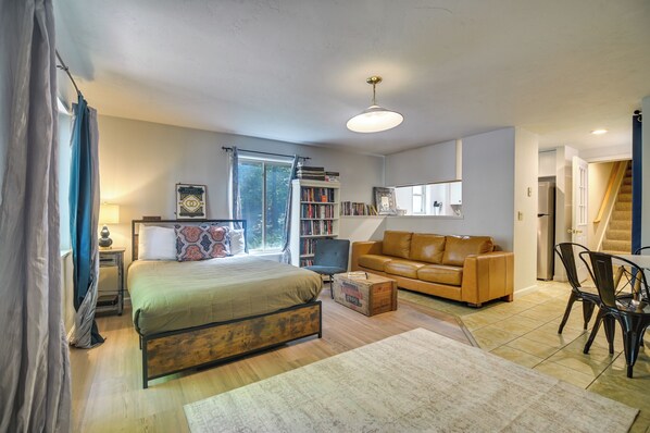 A bedroom with a bed, a sofa, a desk, and a bookshelf.