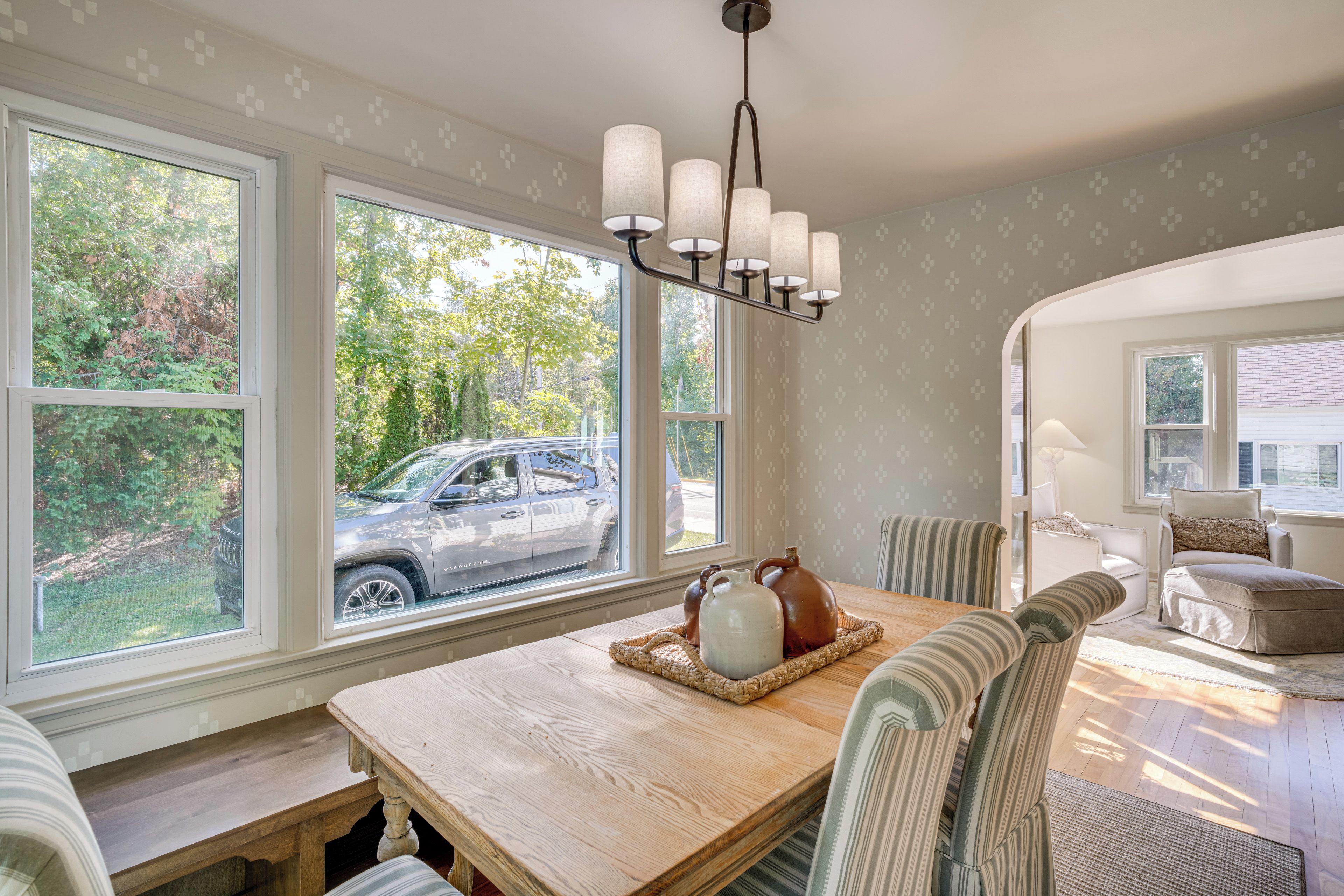 A dining area with a wooden table, chairs, and a chandelier.