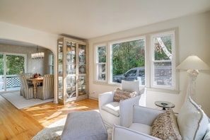 A spacious living area with a dining table, cushioned seating, and large windows offering a view of the outdoors. - Great for Families! Egg Harbor Gem w/ Beach Access (Egg Harbor)