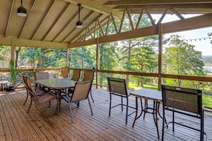 Eine Terrasse im Freien mit Tisch und Stühlen, mit Blick auf eine natürliche Landschaft.
