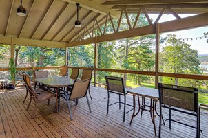 Terraza al aire libre con mesa y sillas, con vistas a un paisaje natural.