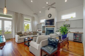 Uma sala de estar ampla com lareira, área de jantar e cozinha com armários.
