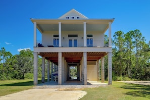 Um edifício de dois andares com varanda e alpendre coberto.
