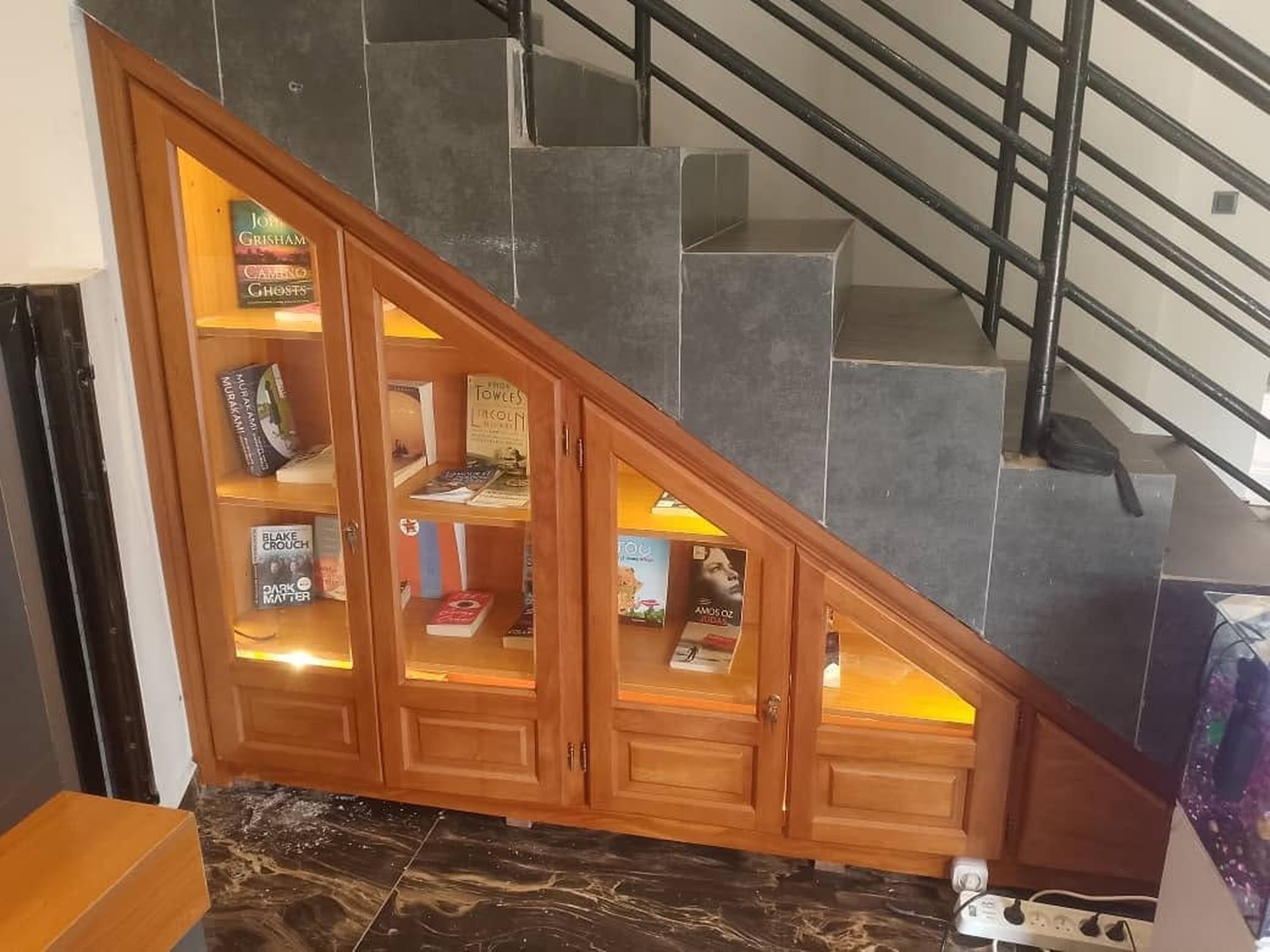 Een trap met een ingebouwde houten boekenkast.