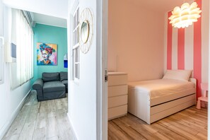 Ein Zimmer mit einem Bett, einem Schminktisch und einem Fenster.