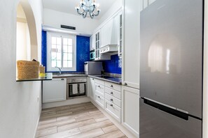 A modern kitchen with white cabinets, a stainless steel refrigerator, and a blue tiled backsplash. - 3-Bedroom Smile Family Home (Los Llanos de Aridane)