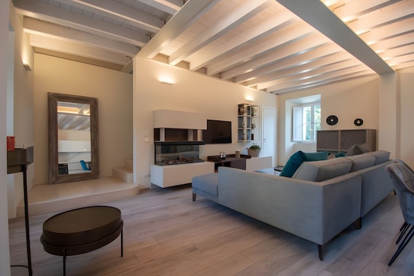 A modern living room with a sectional sofa, a flat-screen TV, and a built-in entertainment unit.