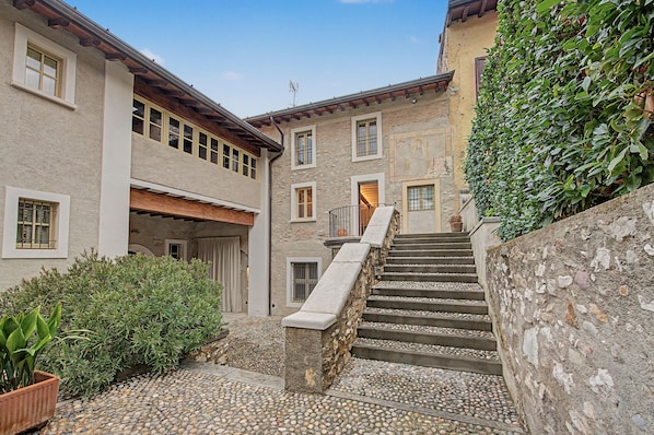 A stone staircase leading to a building with multiple windows and a door.