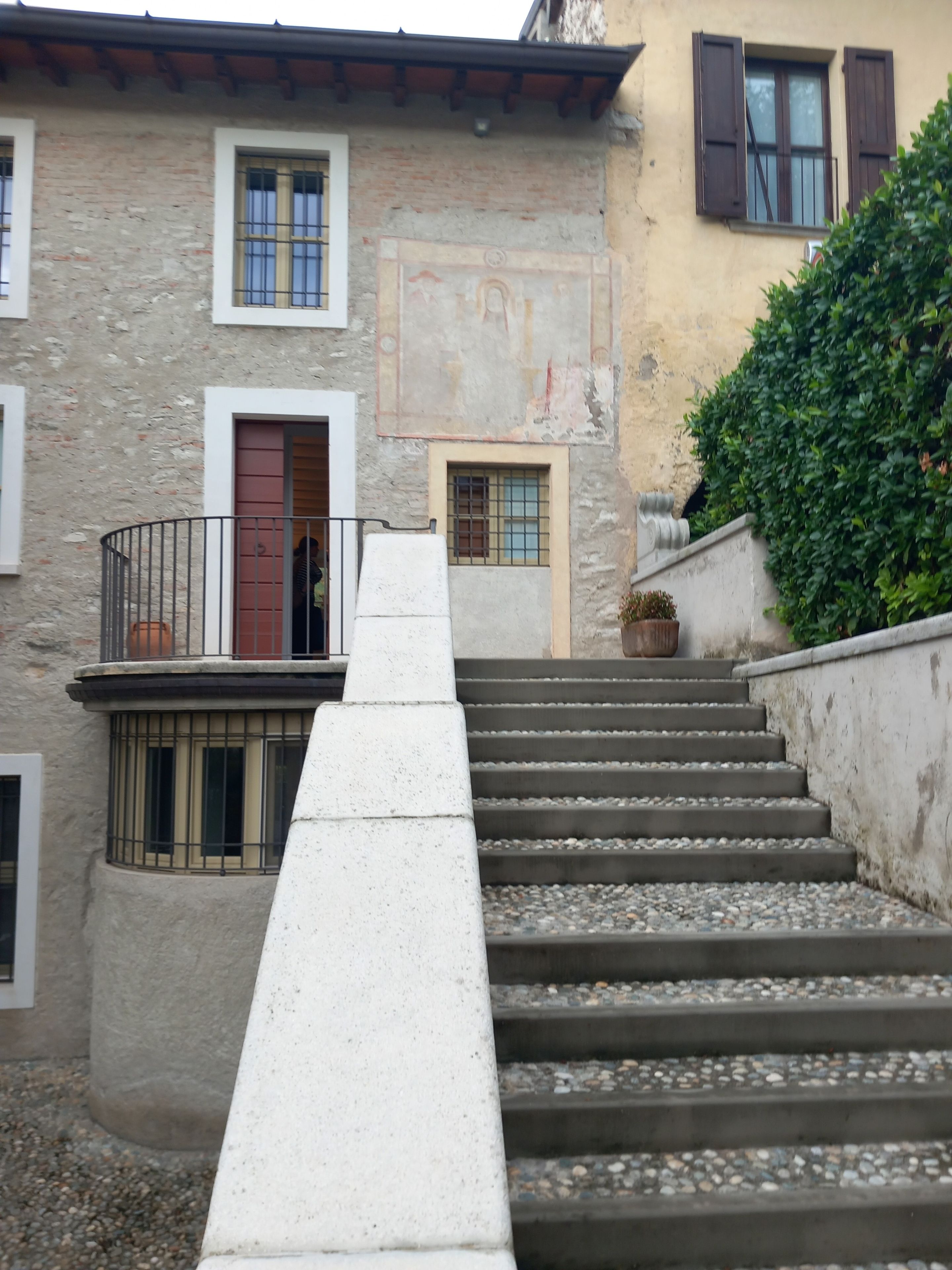 Eine Treppe führt zu einem Gebäude mit mehreren Fenstern und einer Tür.