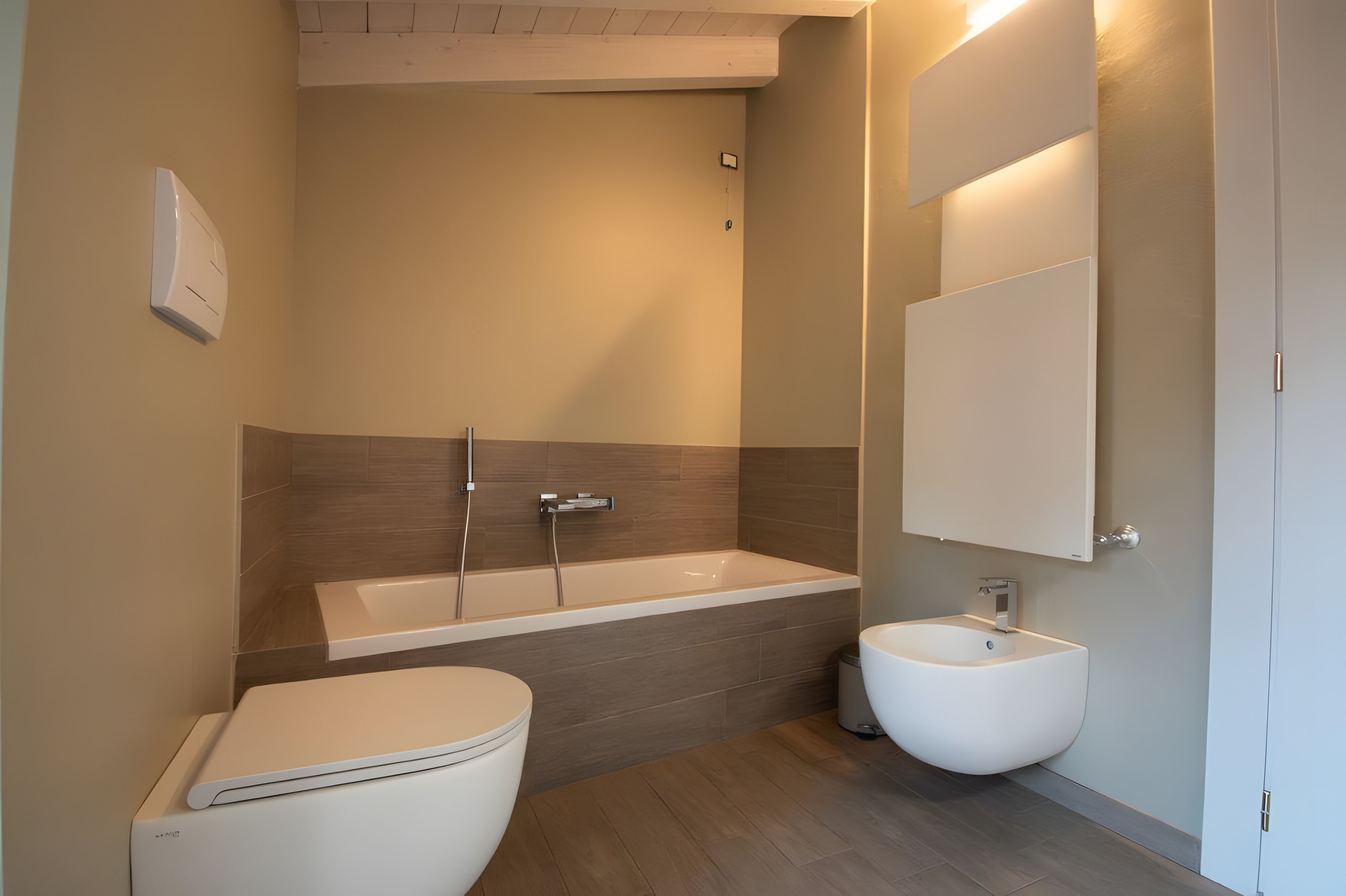 Ein modernes Badezimmer mit Toilette, Bidet und Badewanne.