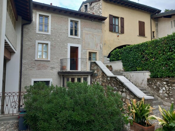 Un edifici de diverses plantes amb façana de pedra, nombroses finestres i una escala que condueix a un segon pis.