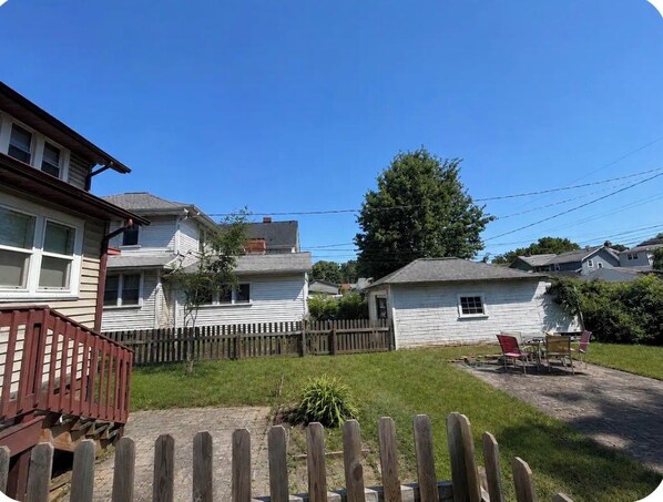 Un barrio residencial con casas, una cerca de madera y cielo despejado.