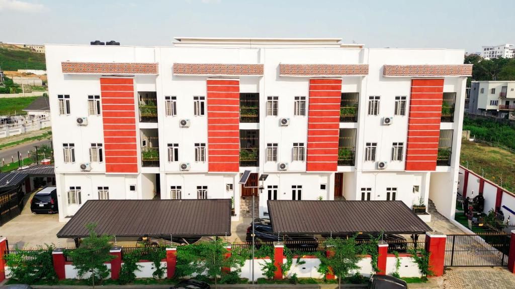 A multi-story building with a symmetrical facade, featuring a central entrance with a covered walkway.