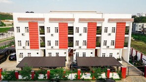 A multi-story building with a symmetrical facade, featuring a central entrance with a covered walkway. - The mason by Trovardig (Abuja)
