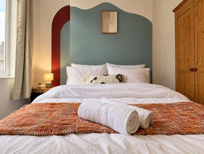 A hotel room with a bed, a nightstand with a lamp, a wooden wardrobe, and a view of the outside. - Stylish Home In Hartlepool, Free Parking & Wifi (Hartlepool)