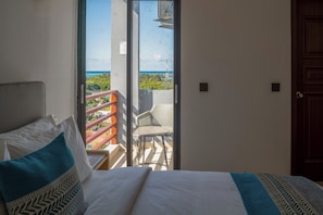 A hotel room with a bed, a view of the ocean, and a balcony with a railing. - Atollios Skyview Hotel (Huraa)