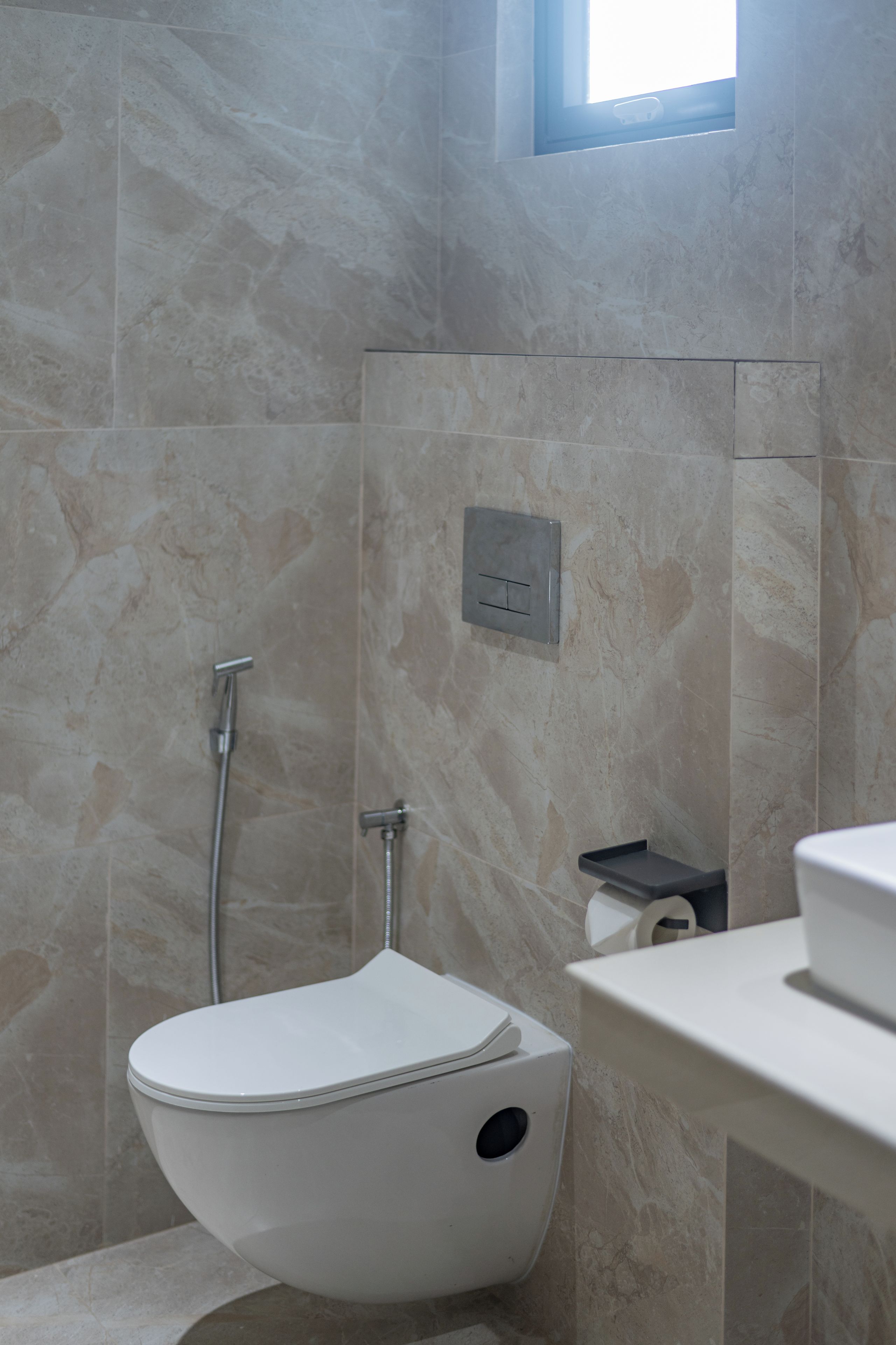 Un bagno con il water, una doccia e una finestra.