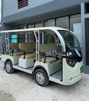 A three-seater golf cart parked outside a building with a sign that reads 'ATOLLIOS SKYVIEW'. - Atollios Skyview Hotel (Huraa)