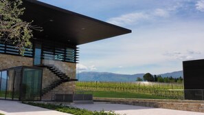 A modern building with a stone facade, a glass staircase, and a vineyard view. - Foresteria Castorani (ALANNO)