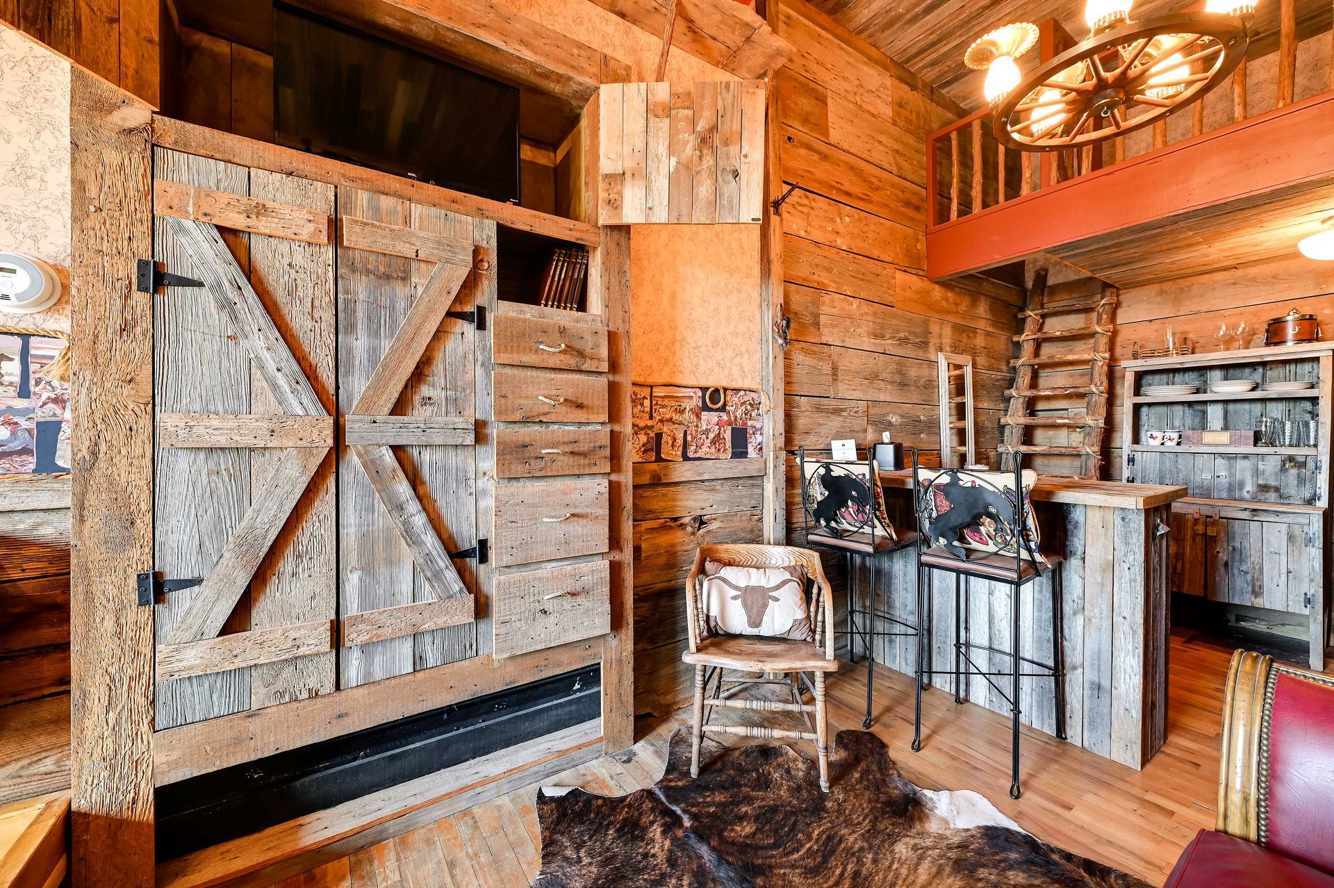 A rustic interior with wooden walls, a bar area, and a cowhide rug.
