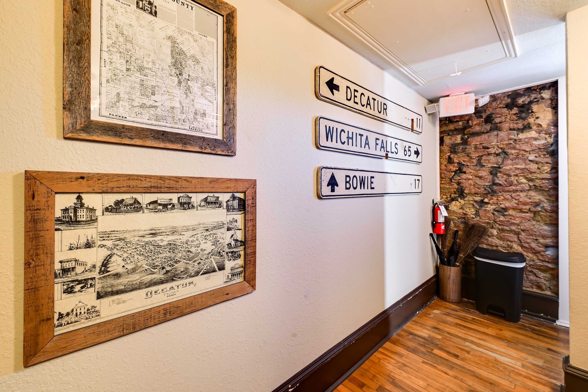 A hallway with framed historical maps and directional signs to Decatur, Wichita Falls, and Bowie.