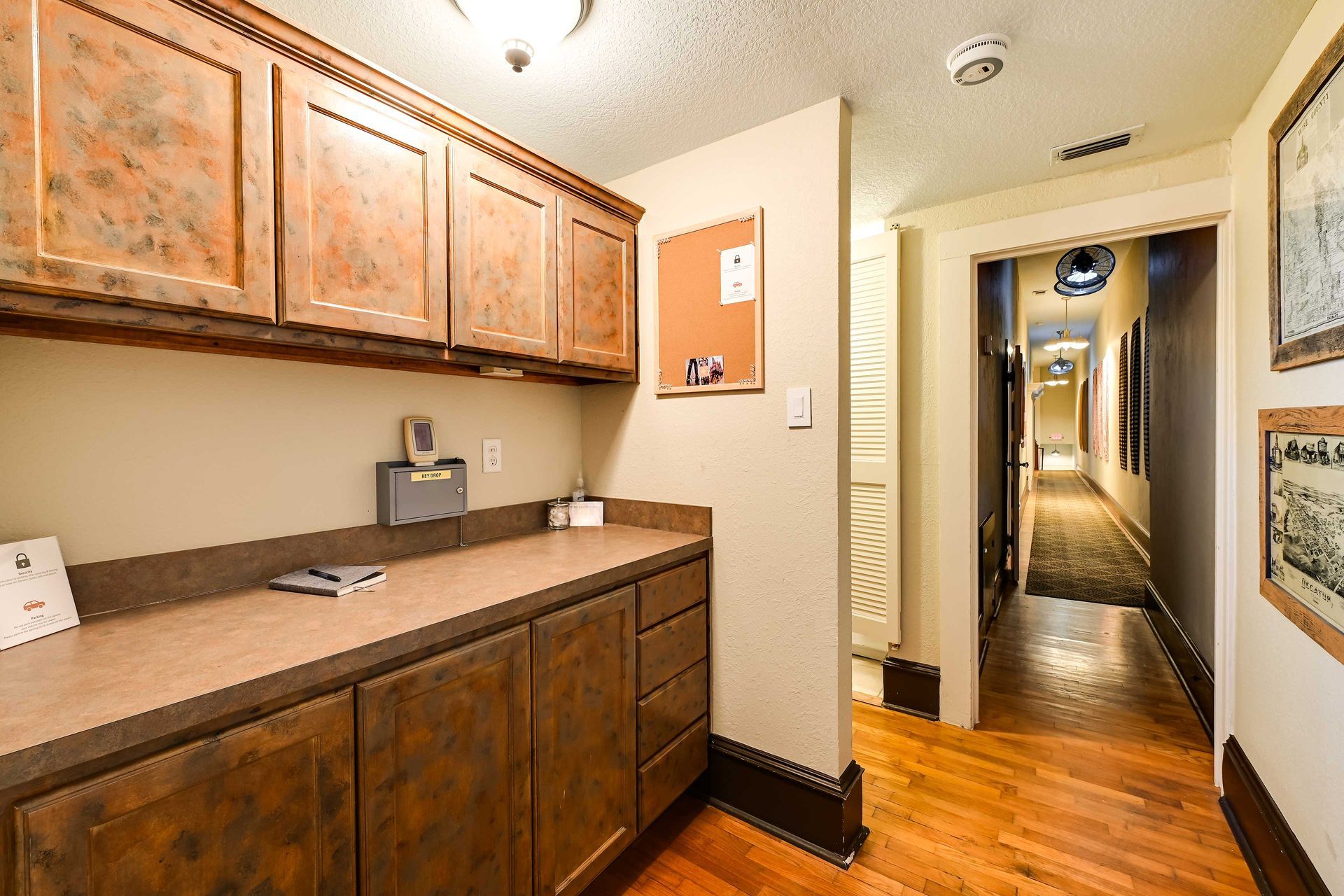 A kitchen with wooden cabinets, a countertop, and a key drop station.