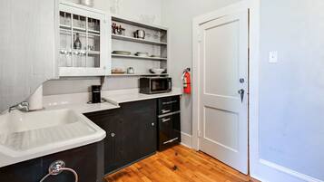 A compact kitchen with a sink, a microwave, and a coffee maker on the countertop.