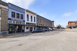 A street with buildings including a bar named 'EZRA ZION CIGAR BAR' and 'DECATUR SUITES'. - Historic Decatur Apt w/ courthouse views (Decatur)