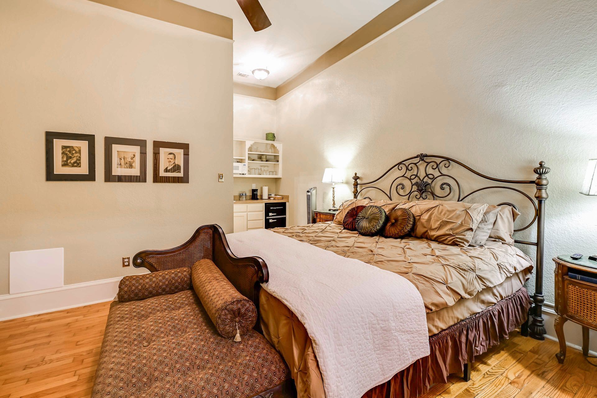 A bedroom with a large bed, a bedside table, a lamp, and a wardrobe.
