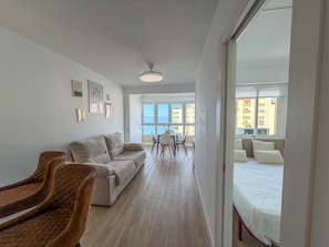 A modern living room with a sofa, chairs, a dining table, and artwork on the walls. - Apartment 'Apartamento en primera línea con vistas al mar en Torrox Costa' (Torrox)