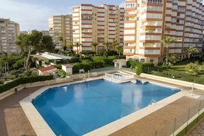 A swimming pool surrounded by greenery and residential buildings. - Apartment 'Apartamento en primera línea con vistas al mar en Torrox Costa' (Torrox)