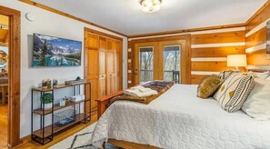 Ein Schlafzimmer mit einem Bett, einem hölzernen Kopfteil, einem Nachttisch, einer Lampe und einem Bild an der Wand.