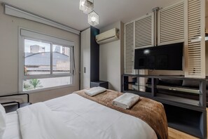 A hotel room with a bed, a television, and a window. - Matoso by Bhomy (São Paulo)