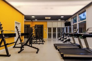 A gym with exercise equipment, treadmills, and a large window. - Matoso by Bhomy (São Paulo)