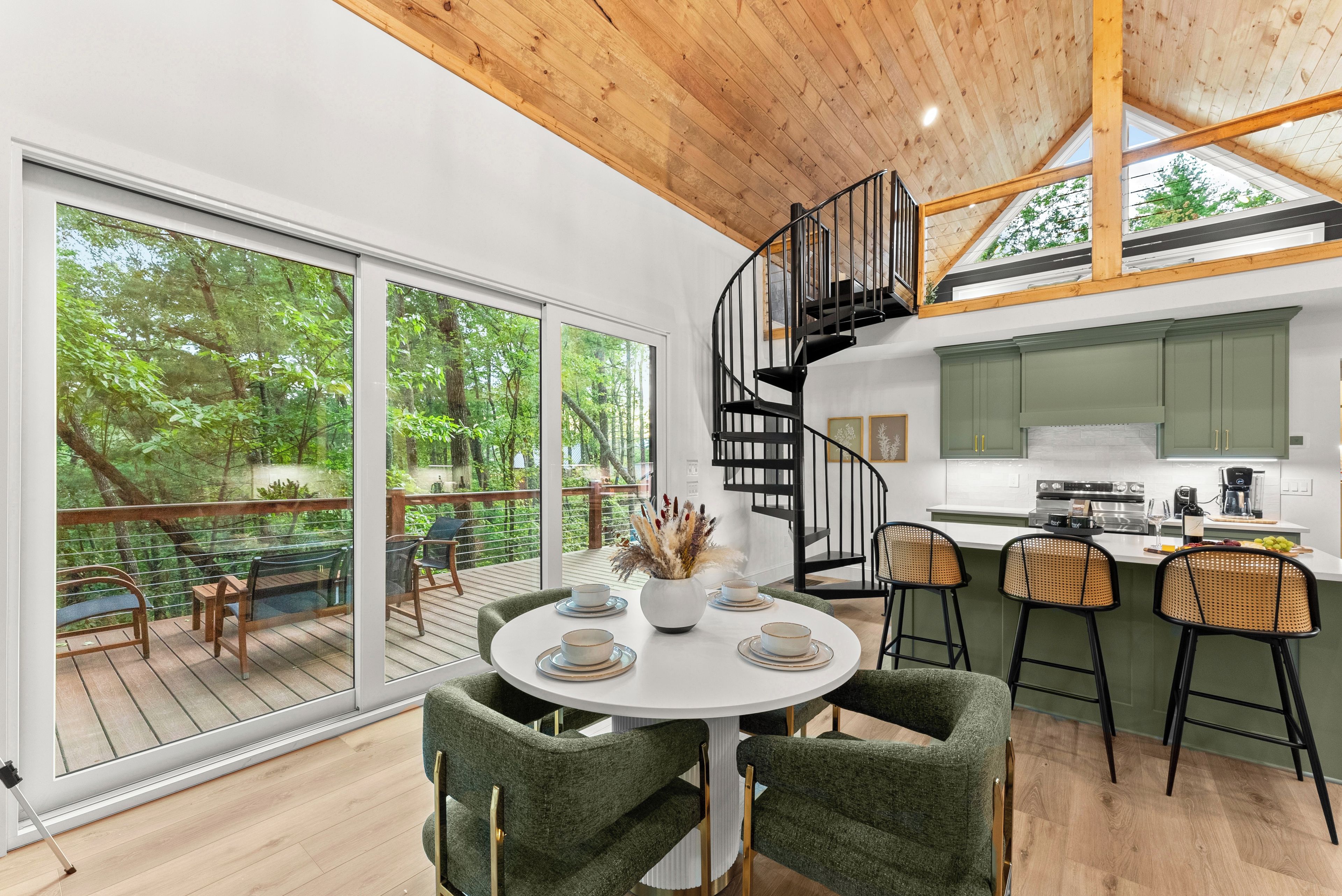 A modern kitchen with a central island, bar stools, and a dining table with chairs.