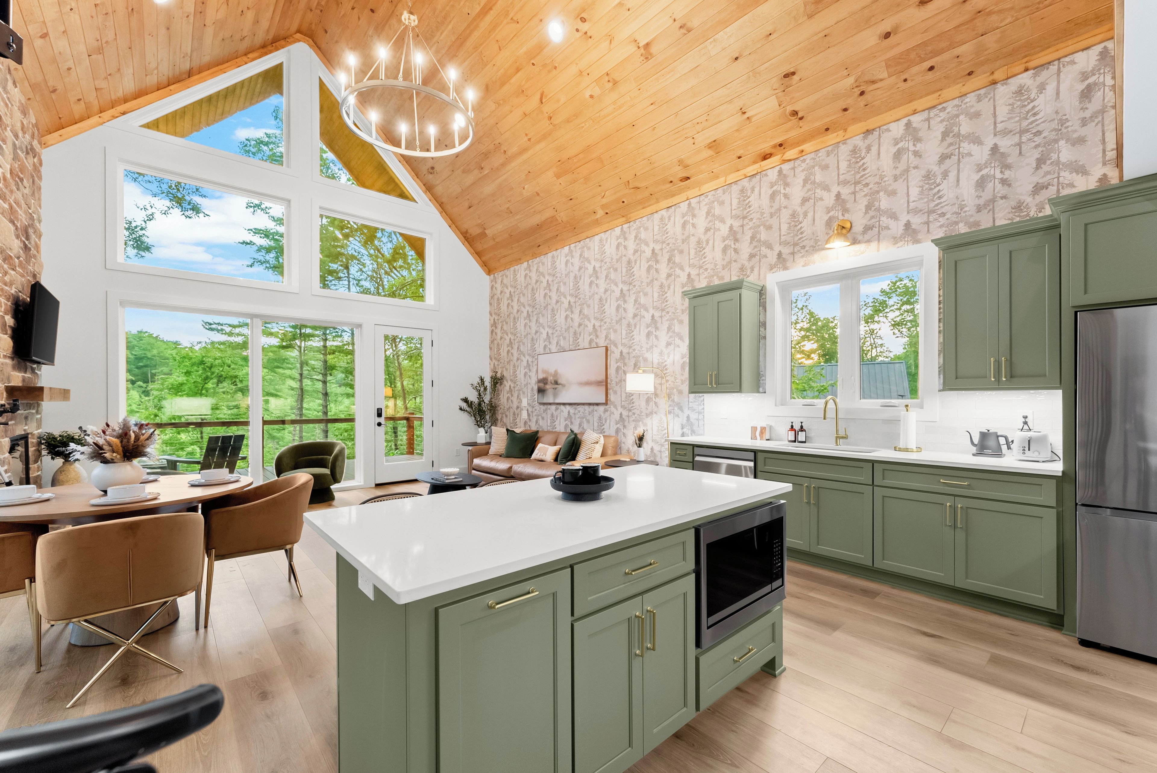 A spacious kitchen with high ceilings, large windows, and a central island.