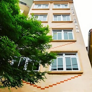 Un edificio de varios pisos con un letrero que dice 'HOTEL RENAM' en la fachada.